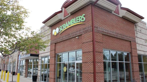 Scramblers store front, brick corner builder with Scramblers logo on front of building. Tree in the corner of image.