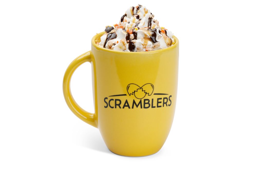 A Scramblers-branded mug filled with the new Whisky Peanut Butter Cocoa topped with whipped cream.